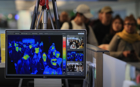 23일 오후 인천국제공항 1터미널 입국장에서 질병관리본부 국립검역소 직원들이 열화상 카메라로 승객들의 체온을 측정하고 있다. 연합뉴스